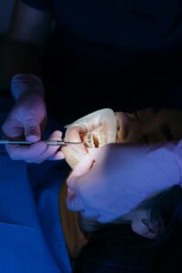 Dentista realizando procedimento com anestesia local em paciente