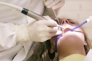Dentista realizando procedimento bucal em paciente para avaliação de xerostomia