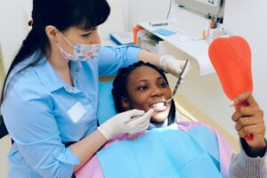 Dentista verificando saúde bucal de paciente durante consulta preventiva