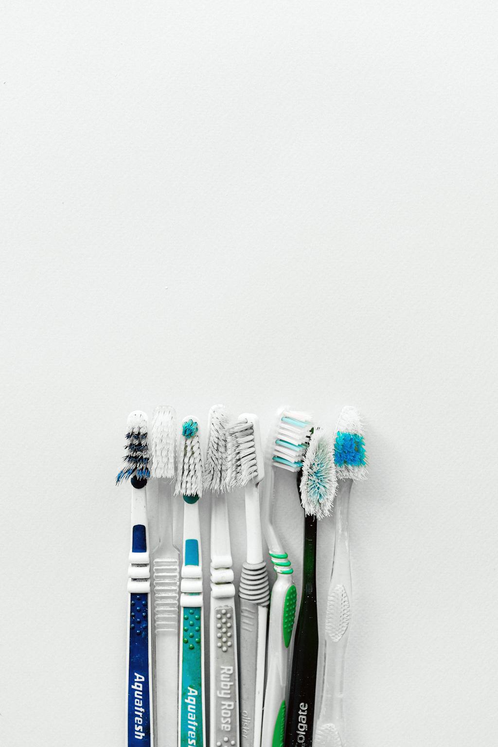 Escovas de dente coloridas representando a importância da higiene bucal completa com fio dental