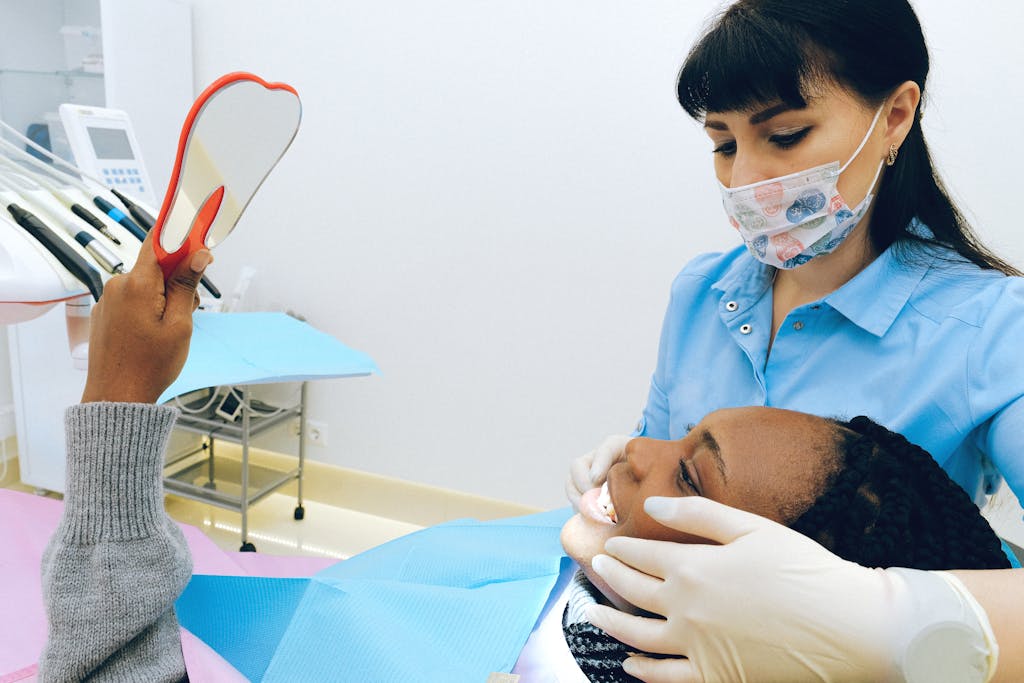 Paciente sorrindo durante consulta odontológica com dentista atencioso
