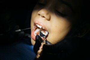 Criança em consulta odontopediátrica realizando exame dental