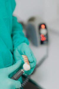 Dentista polindo prótese dentária em laboratório odontológico