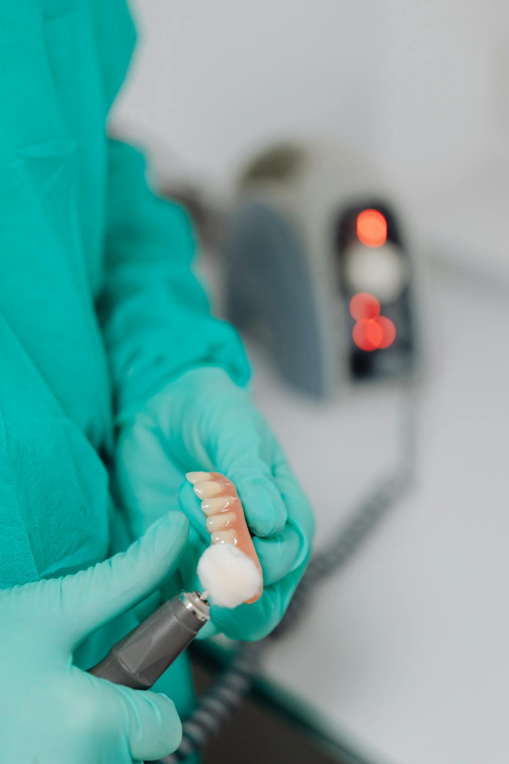 Dentista polindo prótese dentária em laboratório odontológico