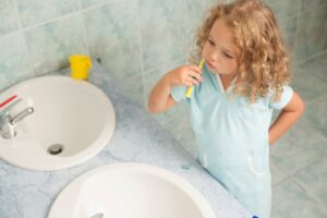 Criança escovando dentes simbolizando a importância de hábitos saudáveis versus tabagismo